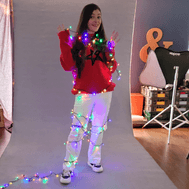 Mujer cubierta con luces de colores en un set de grabacion