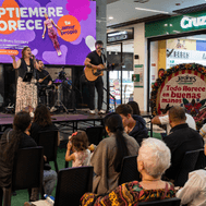Artistas cantando a un publico sobre una tarima de un evento